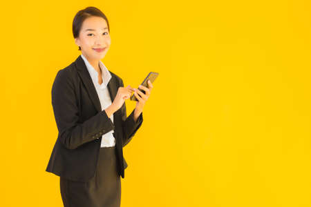 Portrait beautiful young asian woman shopping grocery from supermarket and cart on yellow isolated backgroundの写真素材