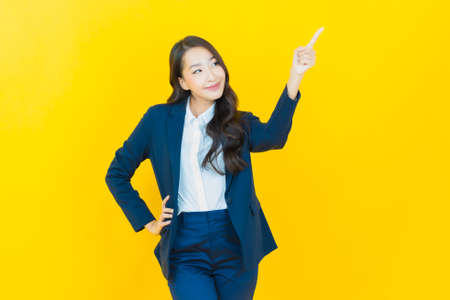 Portrait beautiful young asian woman smile with empty plate dish on color backgroundの写真素材