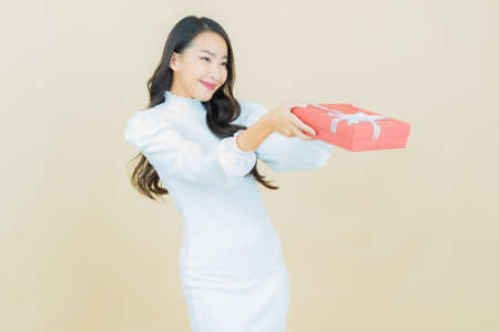 Portrait beautiful young asian woman smile with heart pillow shape on color backgroundの写真素材