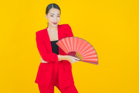 Portrait beautiful young asian woman with fan on color backgroundの写真素材