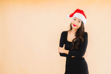 Portrait beautiful young asian woman wear christmas hat on color isolated backgroundの写真素材