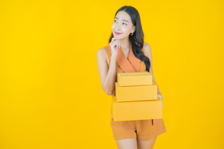 Portrait beautiful young asian woman with box ready for shipping on color backgroundの写真素材