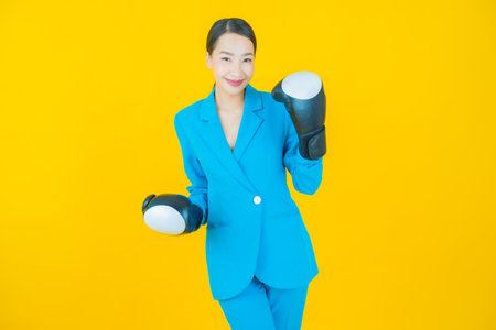 Portrait beautiful young asian woman with boxing glove on color backgroundの写真素材