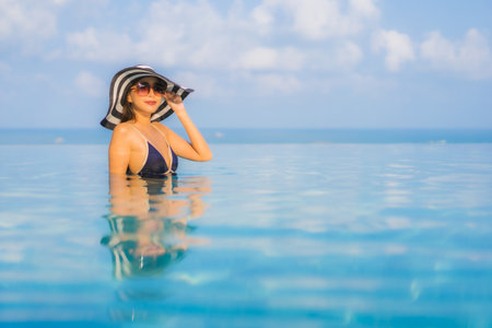 Portrait beautiful young asian woman relax around swimming pool in hotel resort for leisure in vacationの写真素材