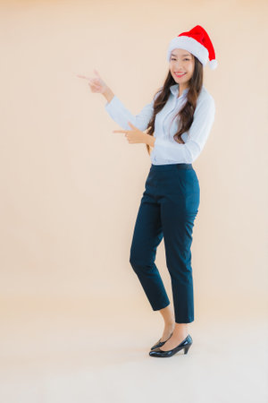 Portrait beautiful young business asian woman wear christmas hat on color isolated backgroundの写真素材