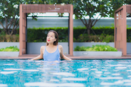 Portrait beautiful young asian woman relax smile leisure around outdoor swimming pool in hotel...