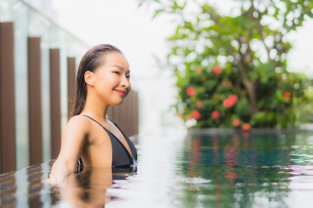 Portrait beautiful young asian woman smile relax leisure around swimming pool in hotel resort for vacationの写真素材
