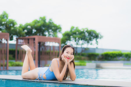 Portrait beautiful young asian woman relax smile leisure around outdoor swimming pool in hotel resortの写真素材