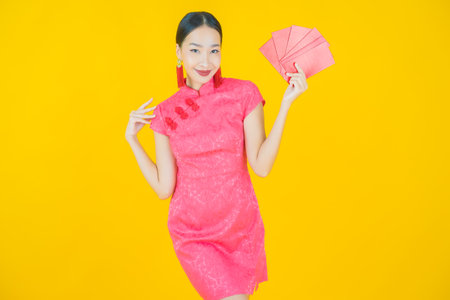 Portrait beautiful young asian woman with red envelope on color backgroundの写真素材
