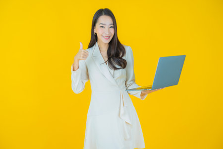 Portrait beautiful young asian woman smile with computer laptop on isolated backgroundの写真素材