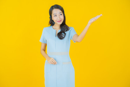 Portrait beautiful young asian woman with call center customer care service center on yellow color backgroundの写真素材