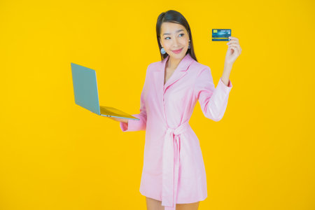 Portrait beautiful young asian woman smile with computer laptop on isolated backgroundの写真素材