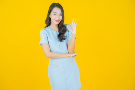 Portrait beautiful young asian woman smile with action on color backgroundの写真素材