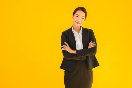 Beautiful portrait young business asian woman happy smile in many action on yellow isolated backgroundの写真素材