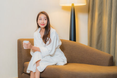 Portrait beautiful young asian woman relax on sofa in living room interiorの写真素材