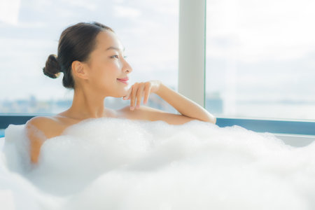 Portrait beautiful young asian woman relax enjoy in bathtub in bathroom interiorの写真素材