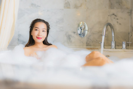 Portrait beautiful young asian woman relax take a bath in bathtub in bathroom interiorの写真素材
