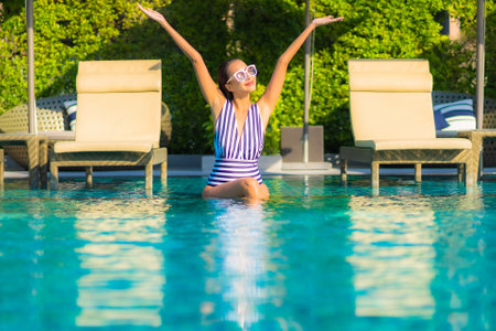 Portrait beautiful young asian woman relax smile leisure on vacation around swimming pool in resort hotelの写真素材