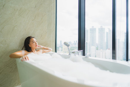 Portrait beautiful young asian woman relax and leisure in bathtub decoration in bathroom interiorの写真素材