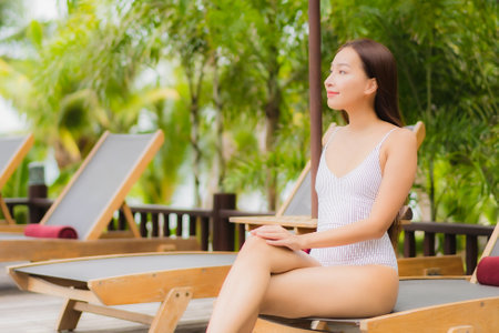 Portrait beautiful young asian woman smile relax around outdoor swimming pool in resort hotel on holiday vacation travel tripの写真素材