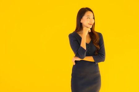 Portrait beautiful young asian woman with action on isolated yellow backgroundの写真素材