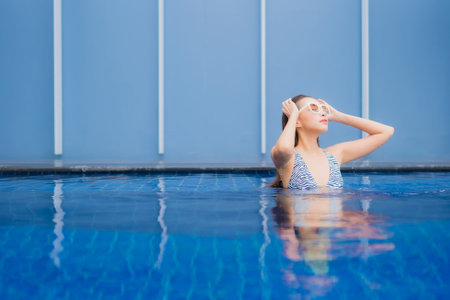 Portrait beautiful young asian woman relax smile around outdoor swimming pool for leisure vacation