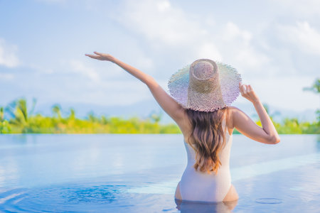 Portrait beautiful young asian woman enjoy around outdoor swimming pool with sea ocean view in travel vacation tripの写真素材