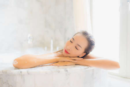 Portrait beautiful young asian woman wear chinese dress with Ang Pao or red letter with cash for chinese new year concept on yellow isolated backgroundの写真素材