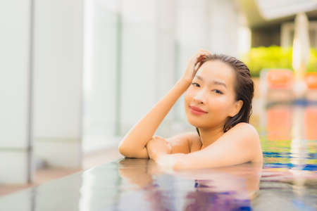 Portrait beautiful young asian women happy smile with coffee and mobile phone on bed in bedroom interiorの写真素材