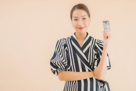 Portrait beautiful young asian woman with smart mobile phone on brown backgroundの写真素材