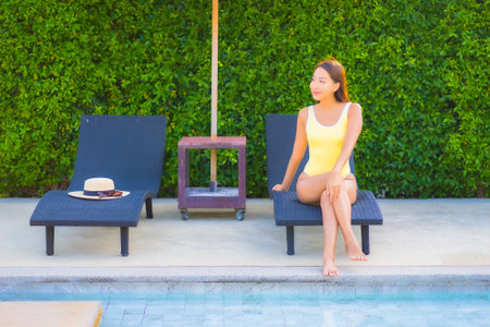 Portrait beautiful young asian woman relax smile enjoy leisure around swimming pool in resort hotel on vacationの写真素材