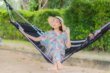Portrait beautiful young asian woman sit on hammock swing around beach sea ocean in holiday vacationの写真素材