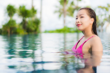 Portrait beautiful young asian woman relax enjoy around outdoor swimming pool in holiday vacationの写真素材