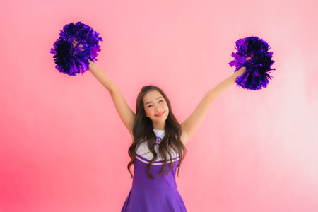Portrait beautiful young asian woman cheerleader smile happy on isolated pink background