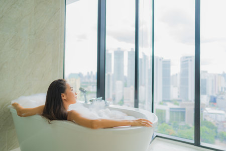 Portrait beautiful young asian woman relax and leisure in bathtub decoration in bathroom interiorの写真素材