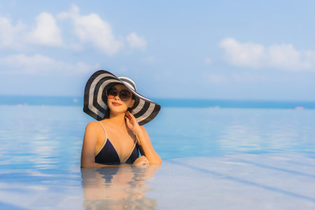 Portrait beautiful young asian woman relax around swimming pool in hotel resort for leisure in vacationの写真素材
