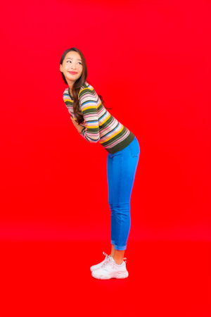 Portrait beautiful young asian woman smile with action on red isolated backgroundの写真素材