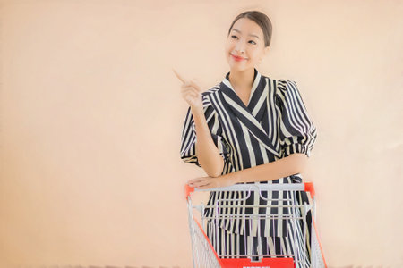 Portrait beautiful young asian woman with shopping cart for shopping groceryの写真素材