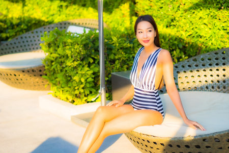 Portrait beautiful young asian woman relax smile leisure on vacation around swimming pool in resort hotelの写真素材