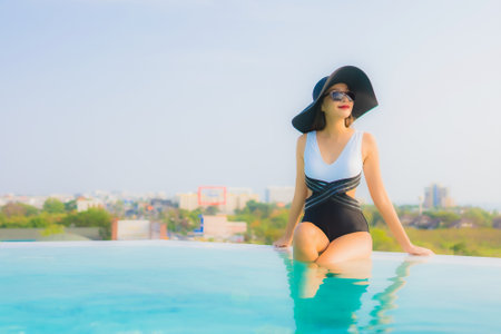 Portrait beautiful young asian woman happy smile relax around outdoor swimming pool in hotel resort for travel vacationの写真素材