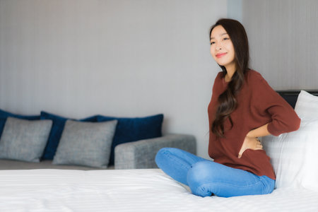 Portrait beautiful young asian woman relax on bed in bedroom interiorの写真素材