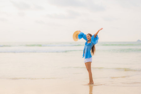 Portrait beautiful young asian woman relax leisure smile around beach sea ocean at sunset timeの写真素材