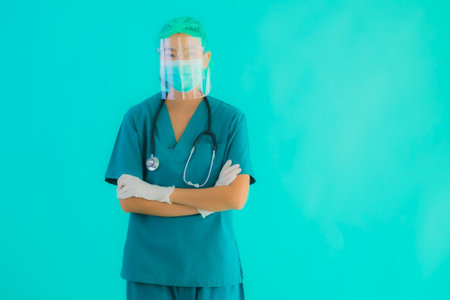 Portrait beautiful young asian doctor woman with mask and eyeglassses for protect from covid19 or coronavirus on blue isolated backgroundの写真素材