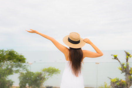 Portriat beautiful young asian woman happy smile around balcony with sea view backgroundの写真素材
