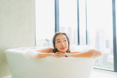 Portrait beautiful young asian woman relax and leisure in bathtub decoration in bathroom interiorの写真素材