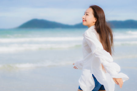 Portrait beautiful young asian woman relax smile around beach sea ocean in holiday vacation travel tripの写真素材
