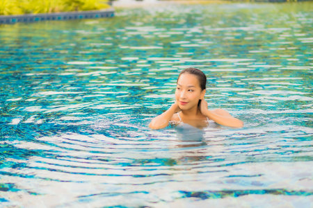 Portrait beautiful young asian woman relax smile leisure around outdoor swimming pool nearly sea beach ocean for holiday vacationの写真素材