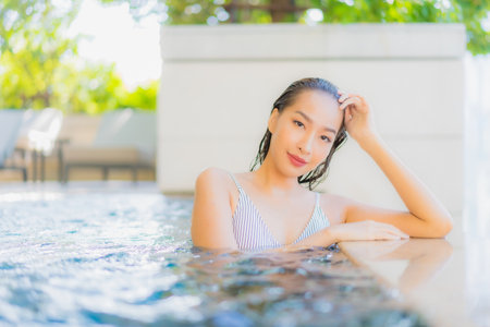 Portrait beautiful young asian woman smile relax leisure around swimming pool for vacationの写真素材