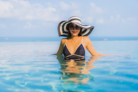 Portrait beautiful young asian woman relax around swimming pool in hotel resort for leisure in vacationの写真素材