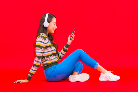 Portrait beautiful young asian woman use smart mobile phone with headphone for listen musicの写真素材